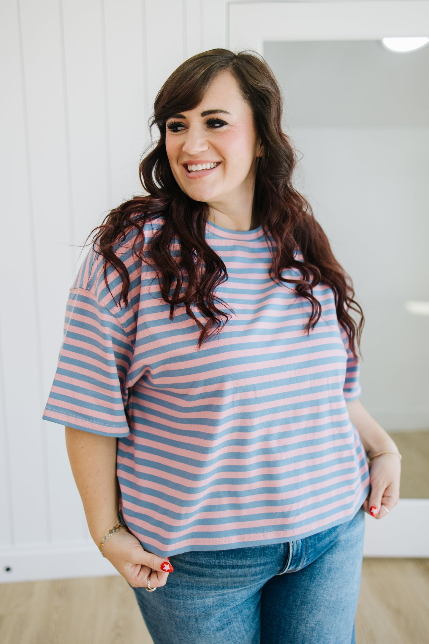 Woman wearing a striped shirt and jeans indoors