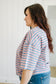 Woman wearing a pink and blue striped shirt with a white background