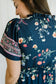 Navy blue dress with floral pattern on a plain background