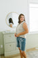 Woman standing in a room with a mirror and window
