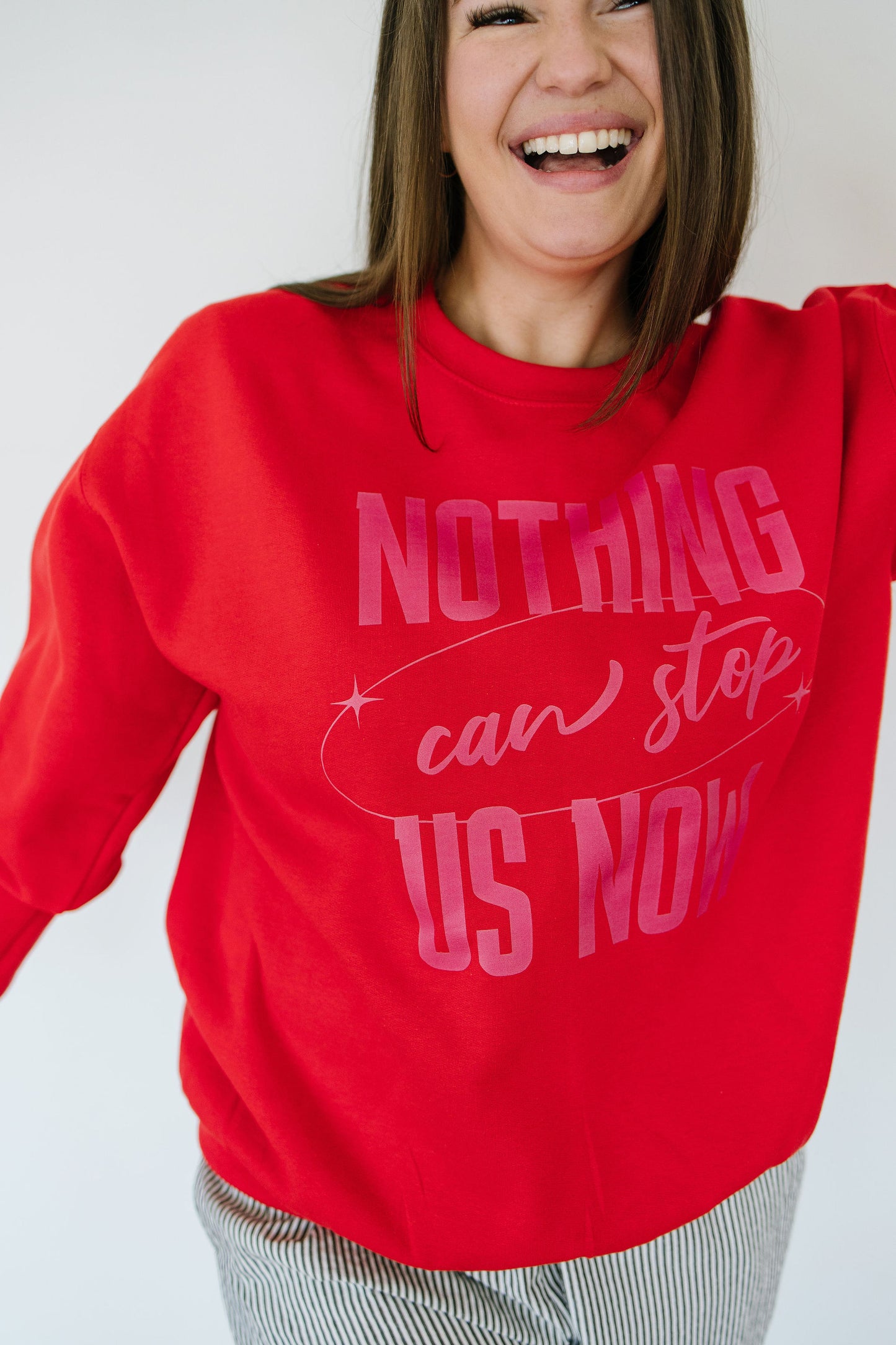 Person wearing a red sweatshirt with motivational text on a plain background