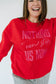 Person wearing a red sweatshirt with motivational text on a plain background