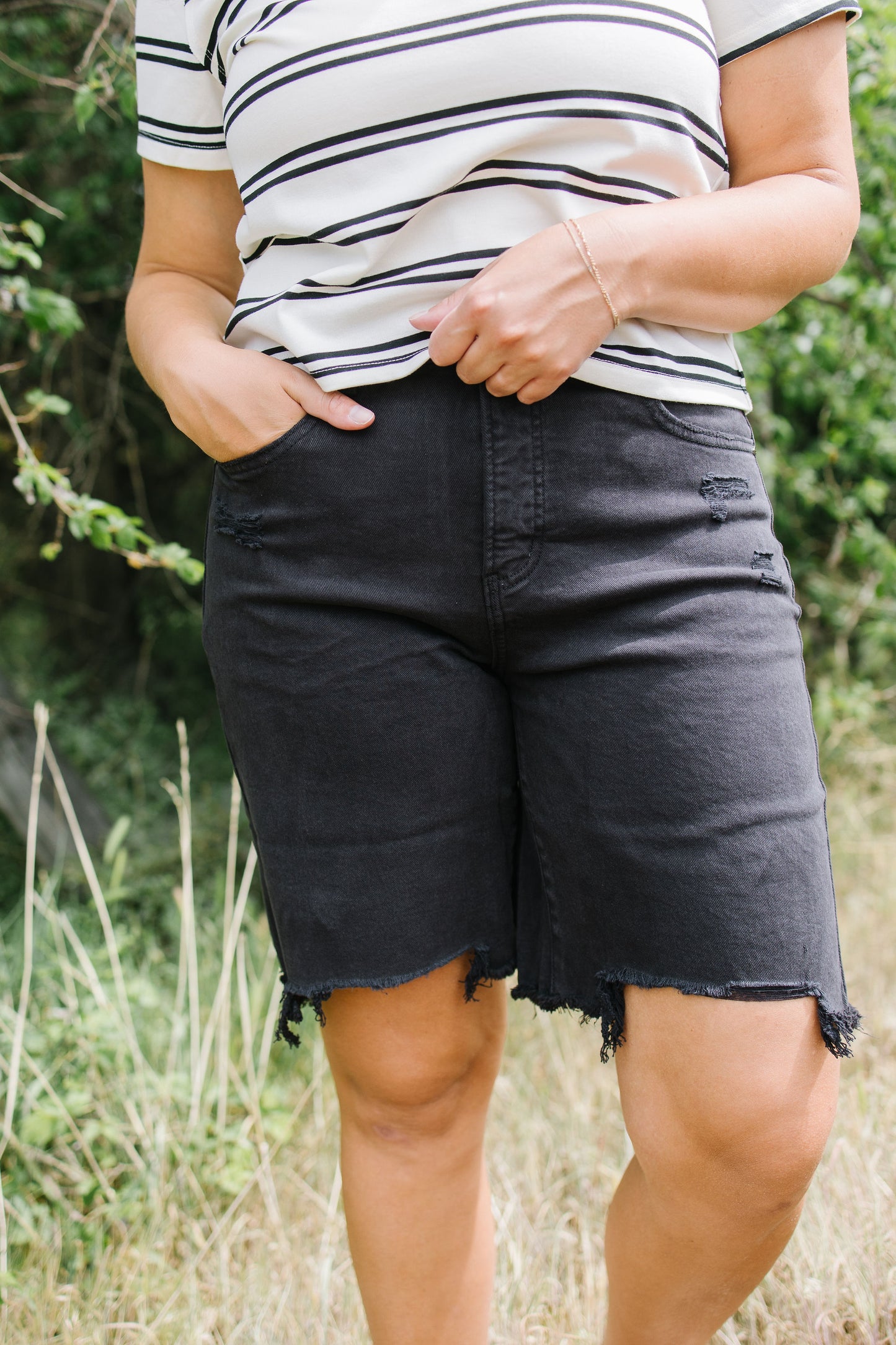 Person wearing black shorts and a striped shirt outdoors