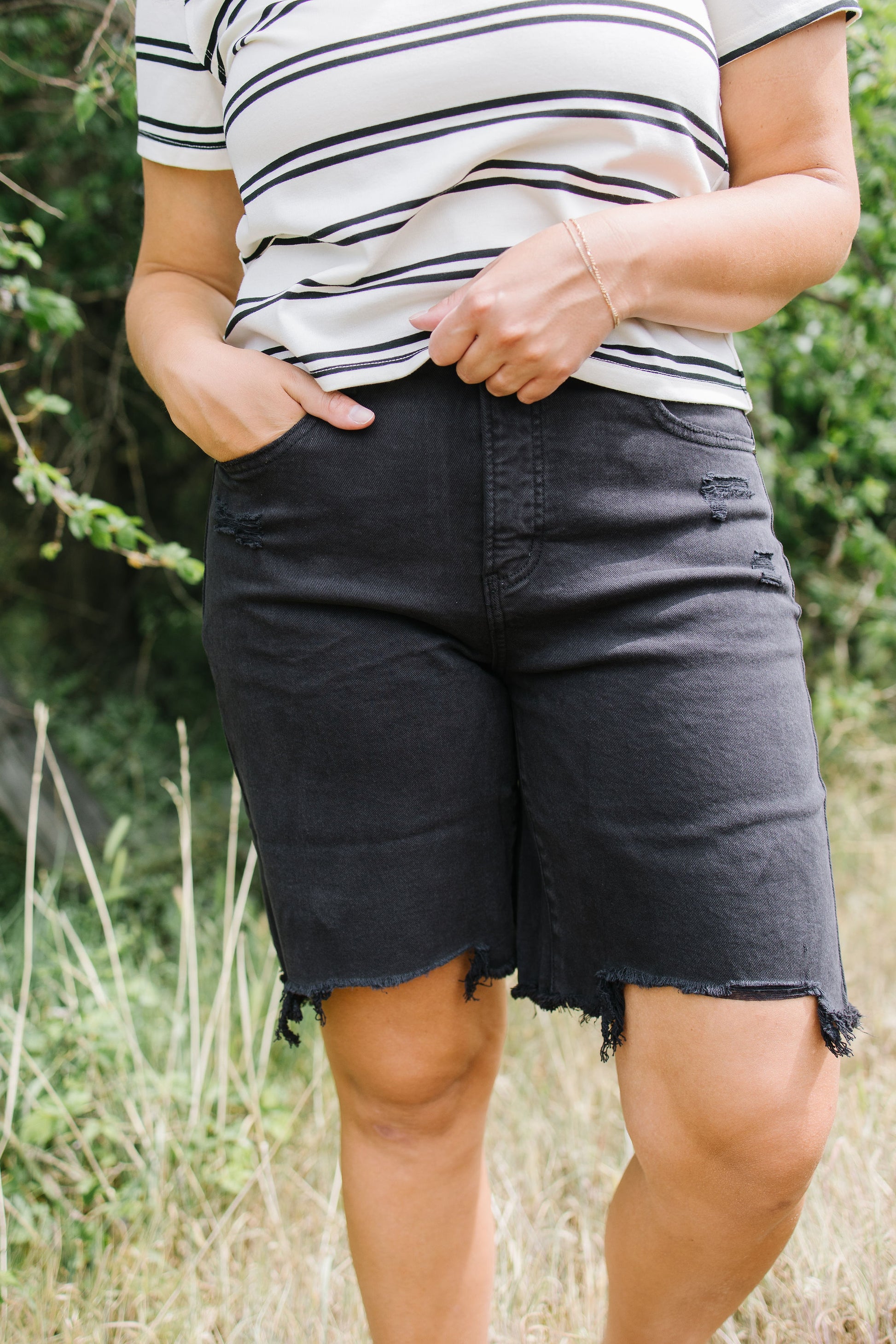 Person wearing black shorts and a striped shirt outdoors