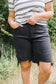 Person wearing black shorts and a striped shirt outdoors