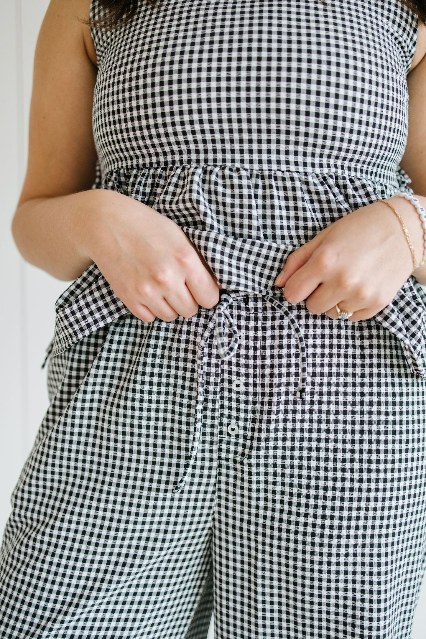 Person wearing a black and white checkered outfit with a white background