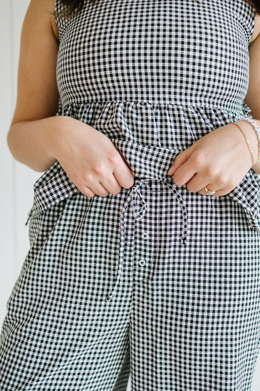 Person wearing a black and white checkered outfit with a white background