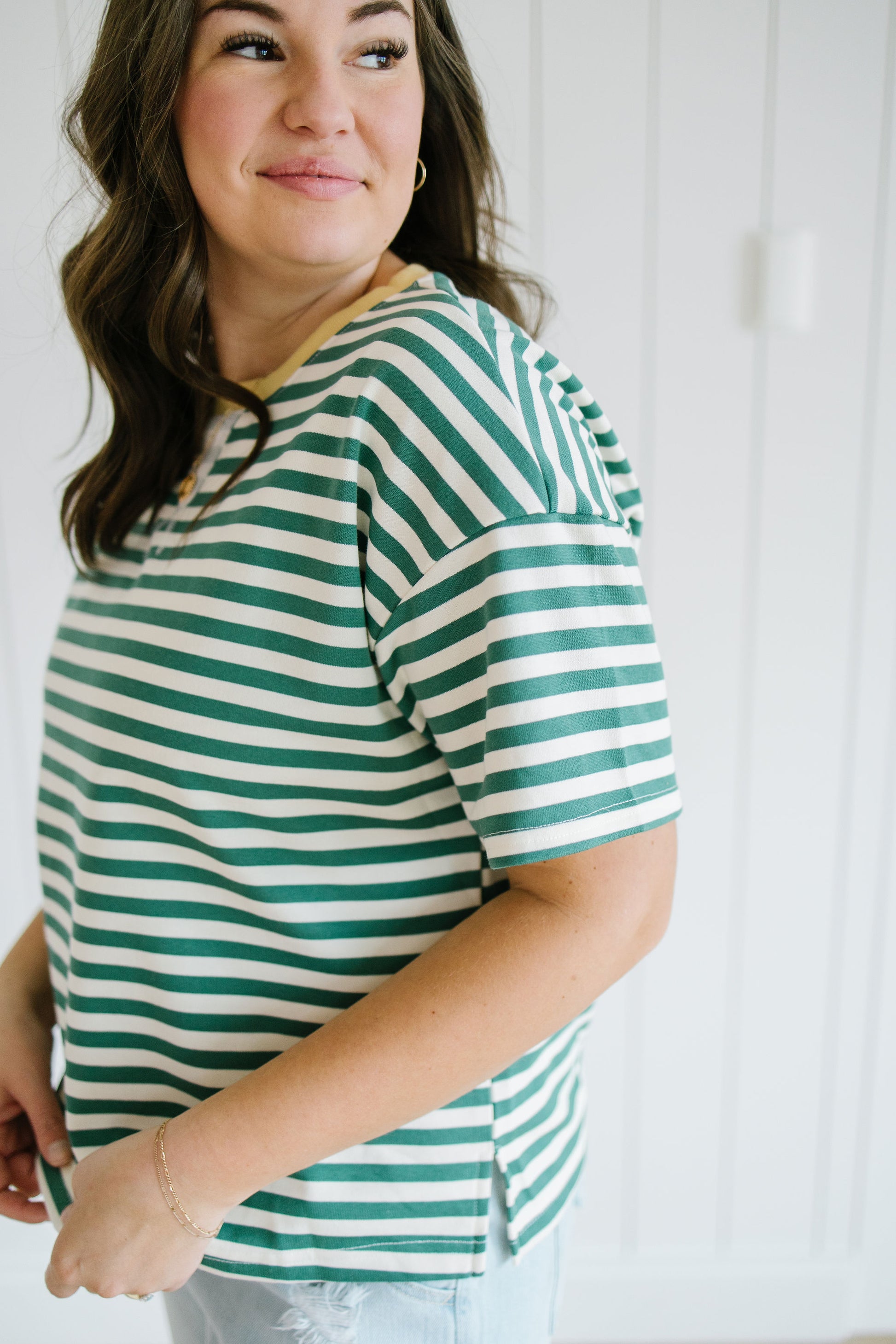 Woman wearing a green and white striped shirt against a white background