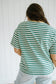 Person wearing a green and white striped shirt against a white background